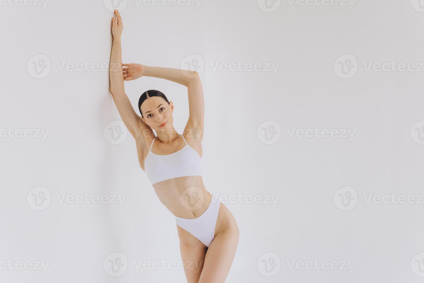 Portrait of beautiful woman with slim body in underwear posing in the white studio background with copy space, mock-up photo