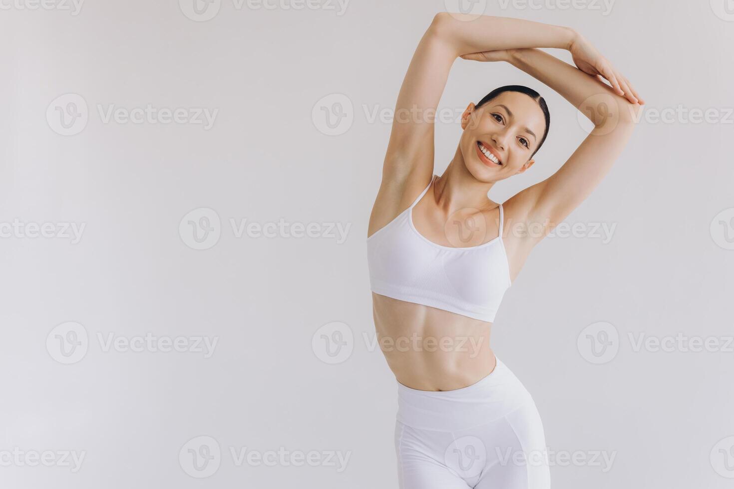 Sporty young woman with slim body doing yoga practice isolated on white background - concept of healthy life and natural balance between body and mental development photo