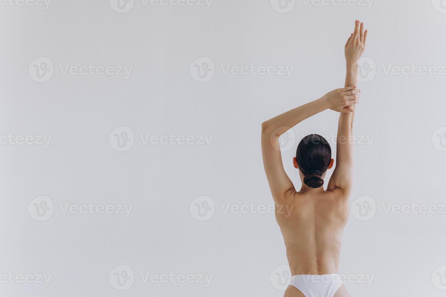 Cropped back rear view young sexy lady woman with slim body perfect skin wearing nude top bra lingerie stand hold hands on thighs isolated on white background. Lifestyle diet fit concept photo