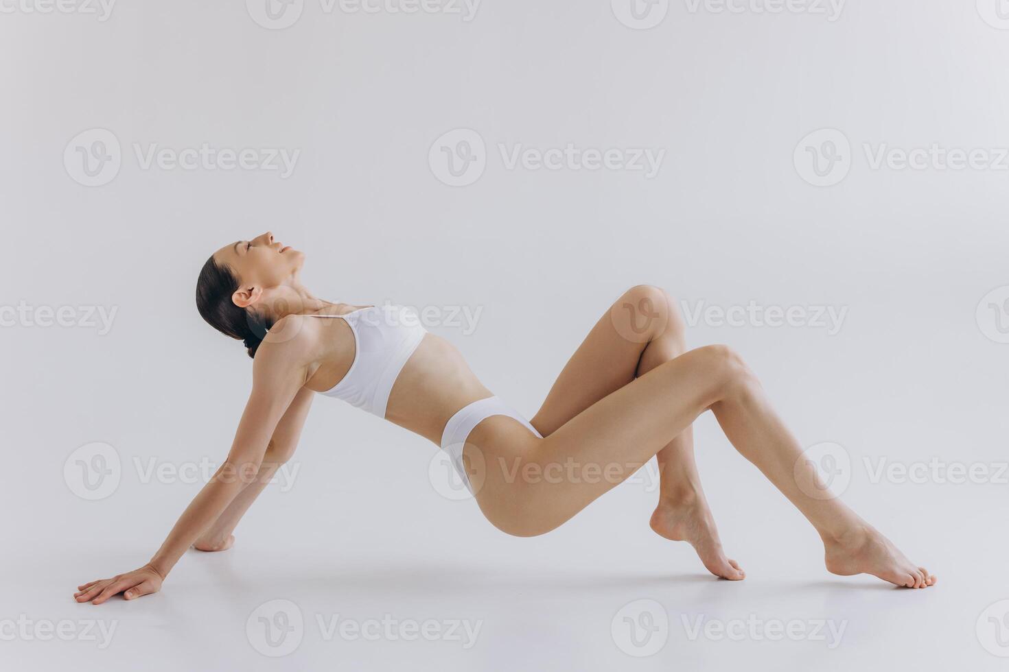 Fit and sporty beautiful woman with perfect shape. Girl in white underwear on the floor. Healthy lifestyle, sport, health care, nutrition and diet concept photo