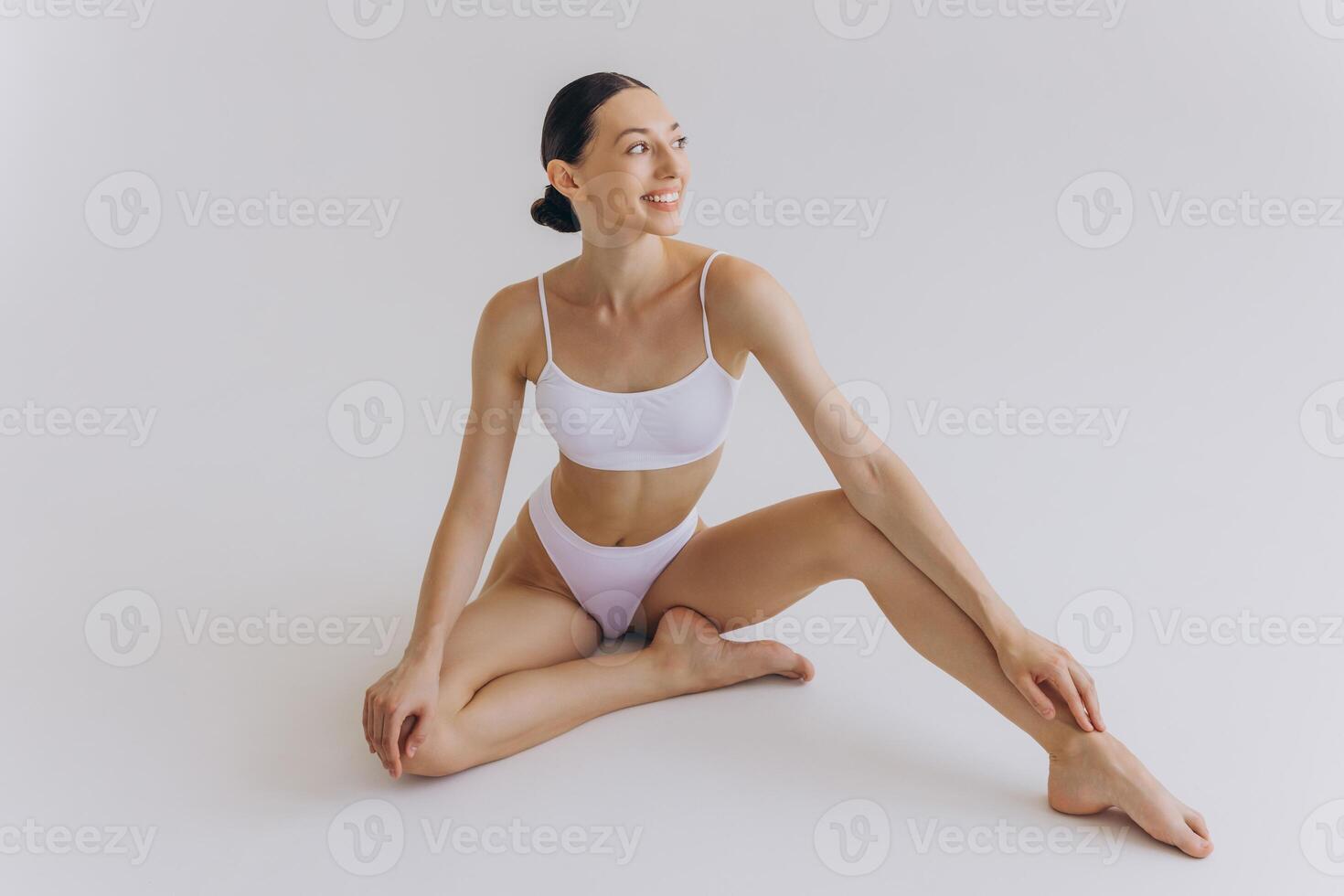 Fit and sporty beautiful woman with perfect shape. Girl in white underwear on the floor. Healthy lifestyle, sport, health care, nutrition and diet concept photo