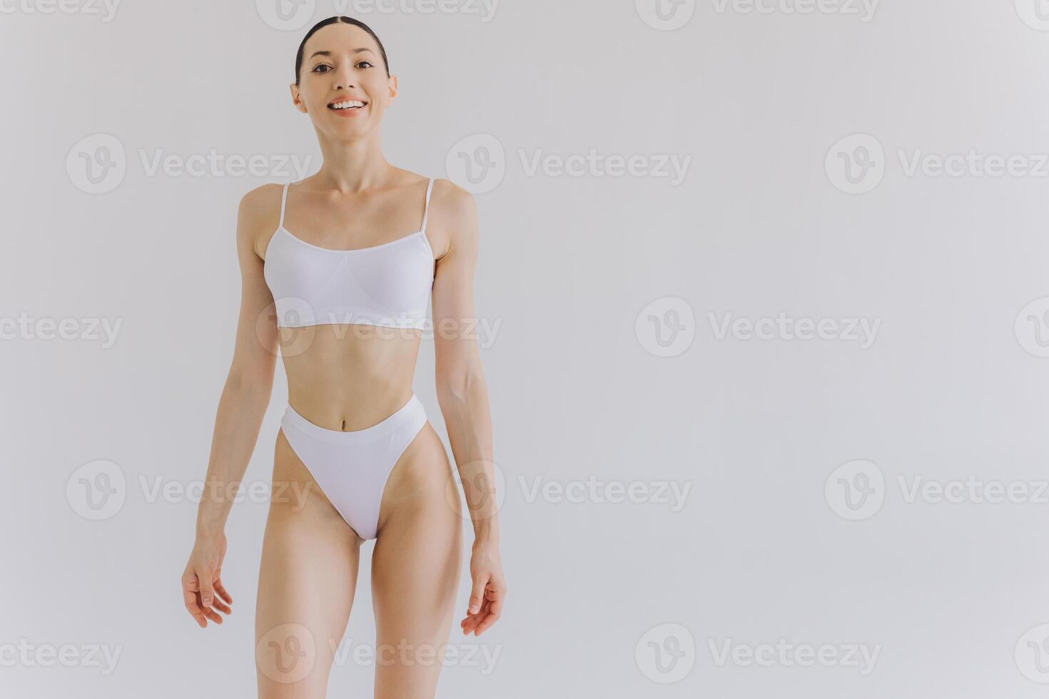 Portrait of beautiful woman with slim body in underwear posing in the white studio background with copy space, mock-up photo