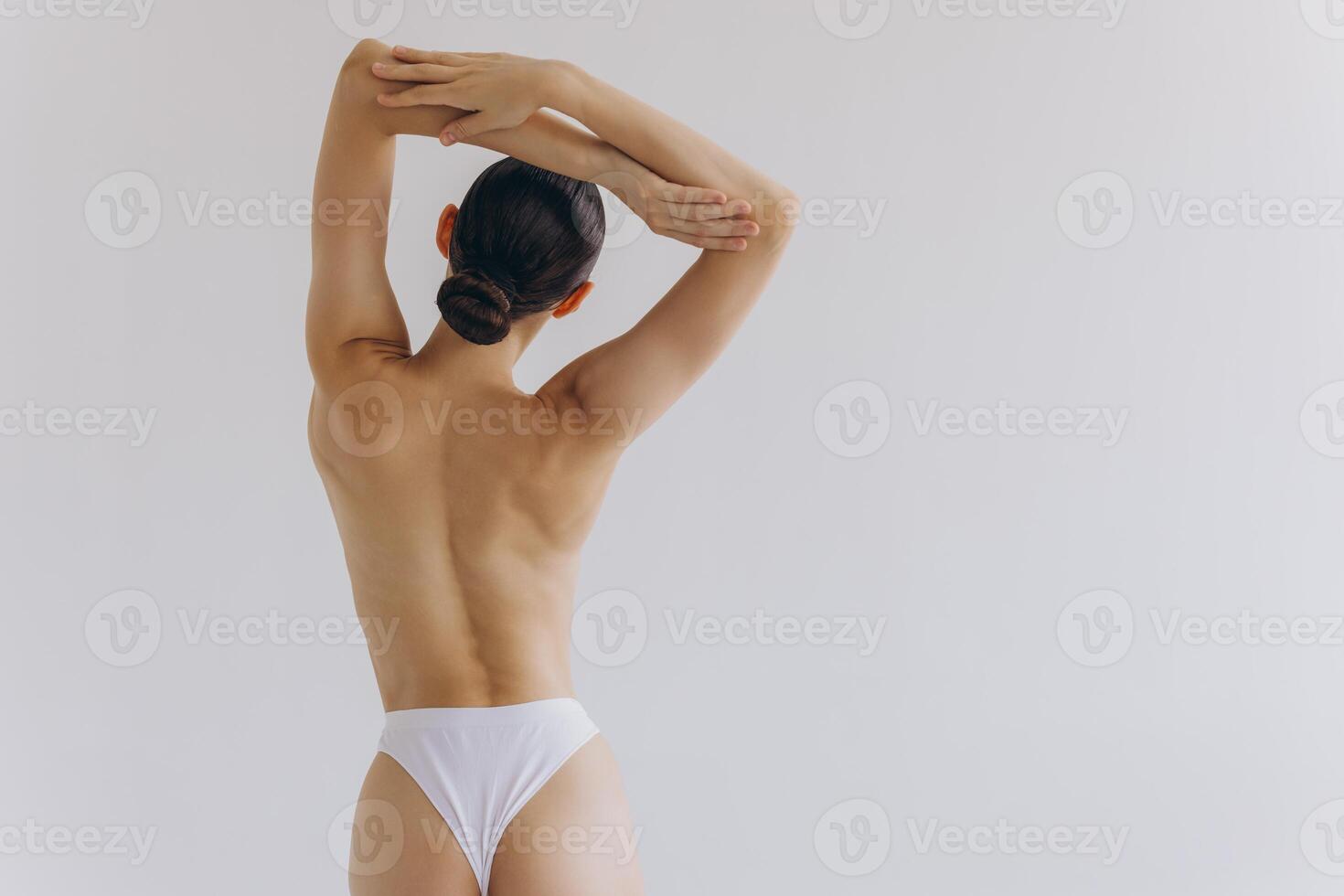 Cropped back rear view young sexy lady woman with slim body perfect skin wearing nude top bra lingerie stand hold hands on thighs isolated on white background. Lifestyle diet fit concept photo