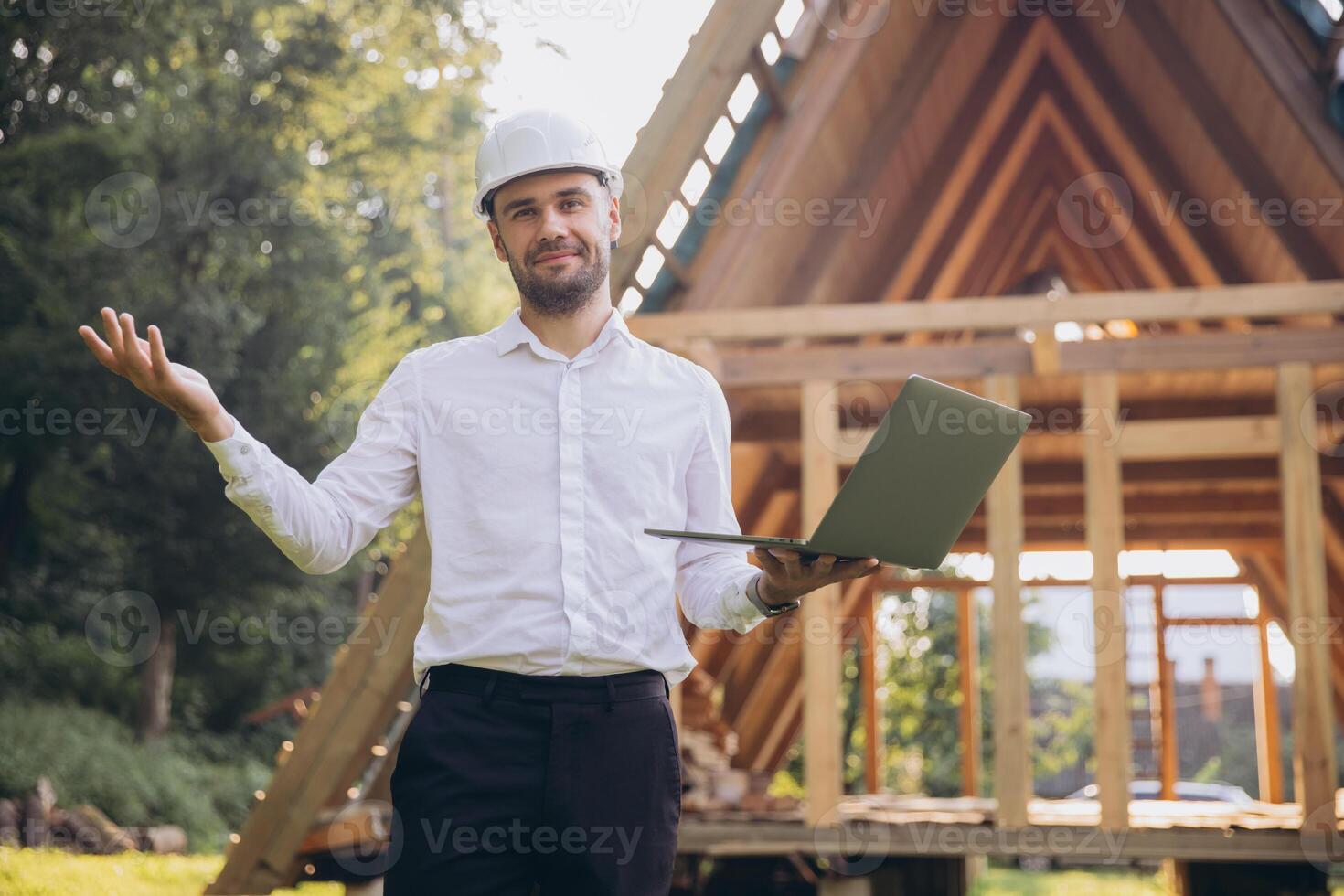 Man builder. Foreman with laptop. Contractor for construction company. Architect in unfinished building. Builder in wooden house under construction. Man engineer from construction team photo