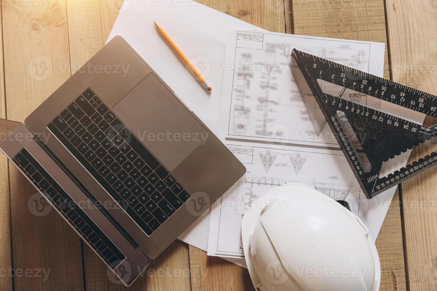 Top view mock -up architectural office desk with copy space, wooden floor with laptop, white helmet construction, pencil, ruler and paper roll, copy space, mock up photo