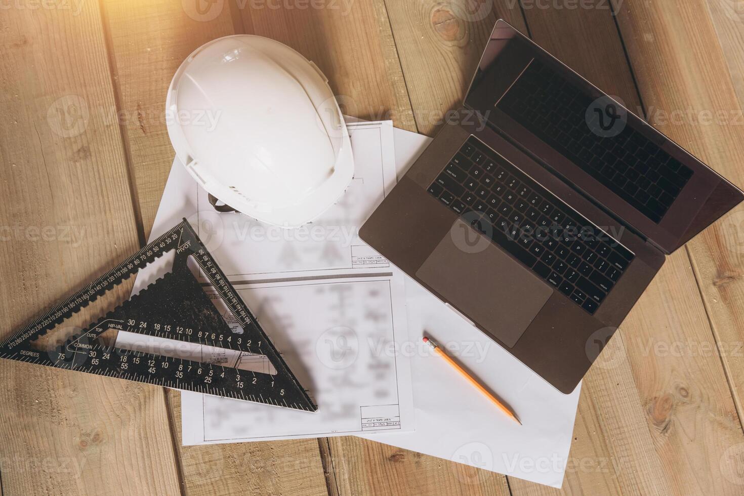 Top view mock -up architectural office desk with copy space, wooden floor with laptop, white helmet construction, pencil, ruler and paper roll, copy space, mock up photo