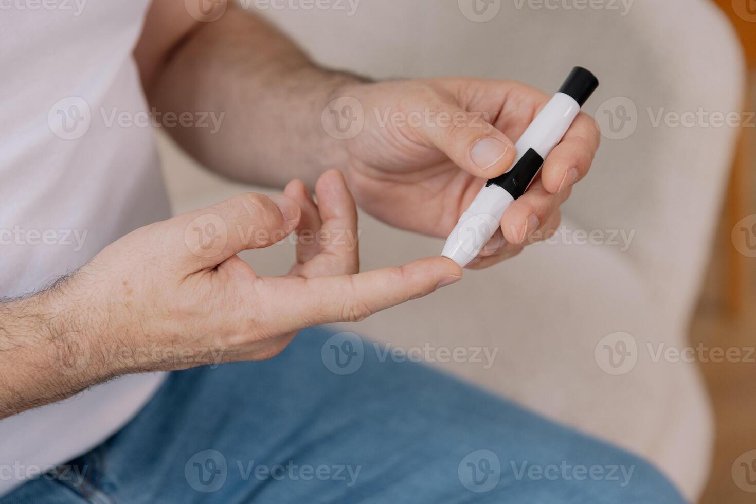 Diabetic senior man on wheelchair checking blood sugar level with fingerstick testing glucose meter. Elderly man with type 1 diabetes using blood glucose monitor at home. photo