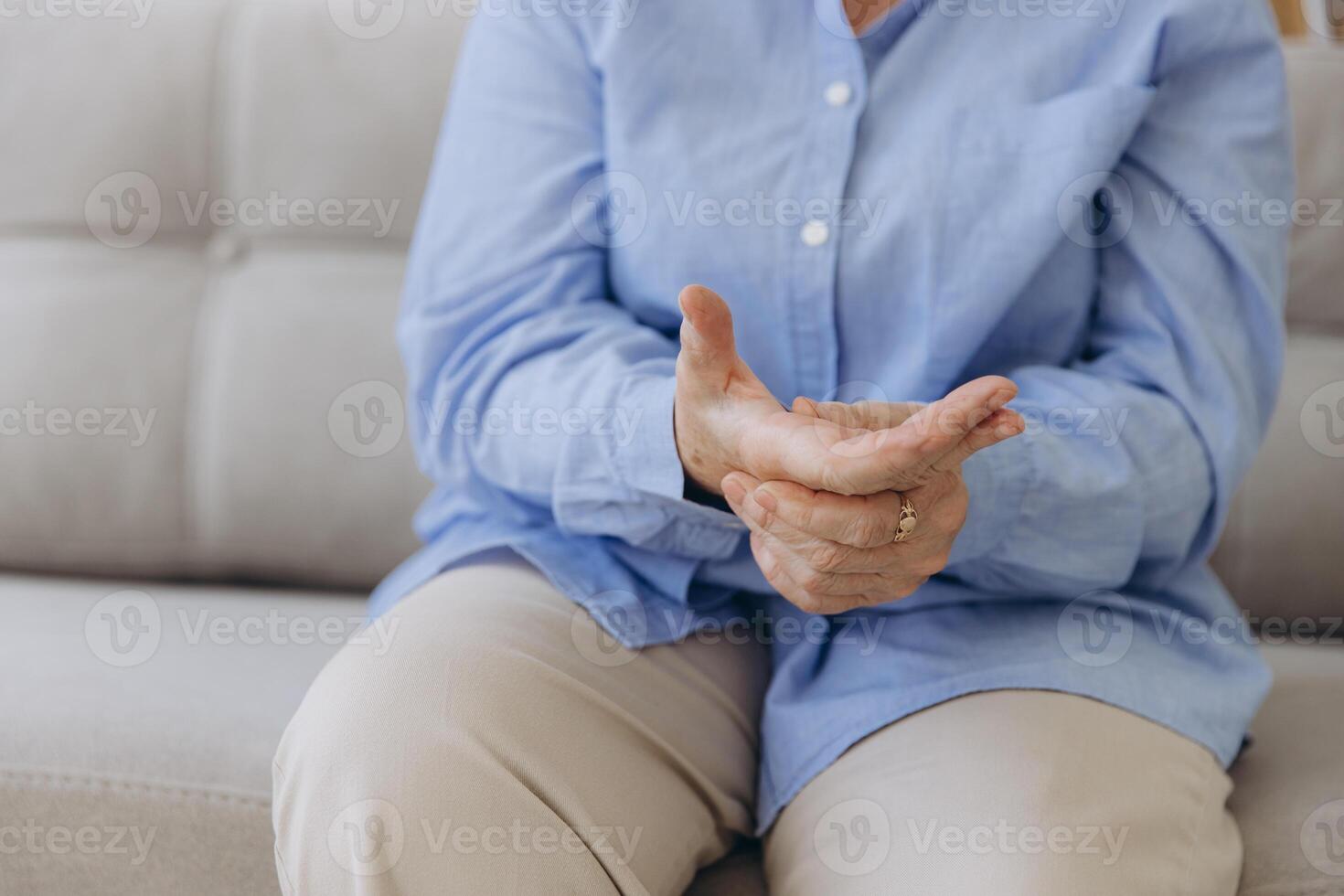 Elderly woman suffering from pain in hand, close up photo