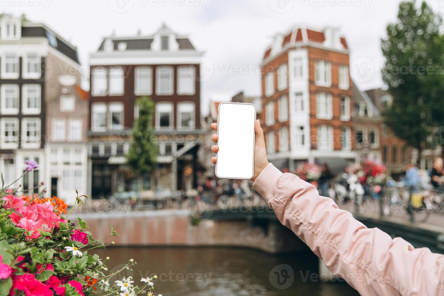 Female tourist taking photo with mobile phone in Amsterdam, Netherlands. Mockup concept