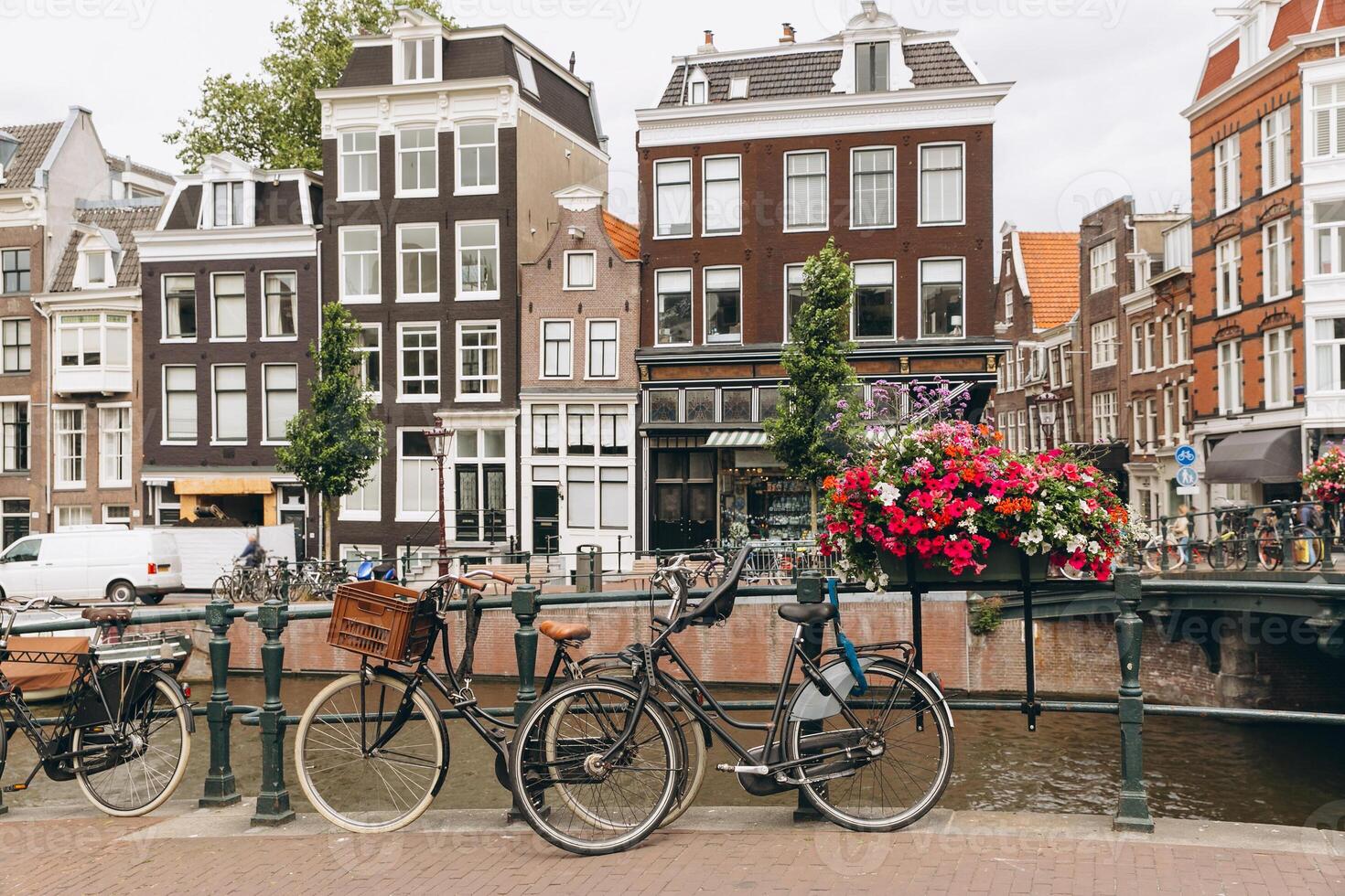 Old bicycle on the bridge in Amsterdam, Netherlands against a canal during summer. Postcard iconic view. Tourism concept. photo