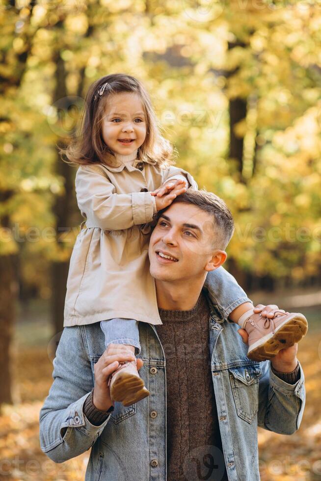 Happy dad and little daughter walking in autumn park, father's day concept photo