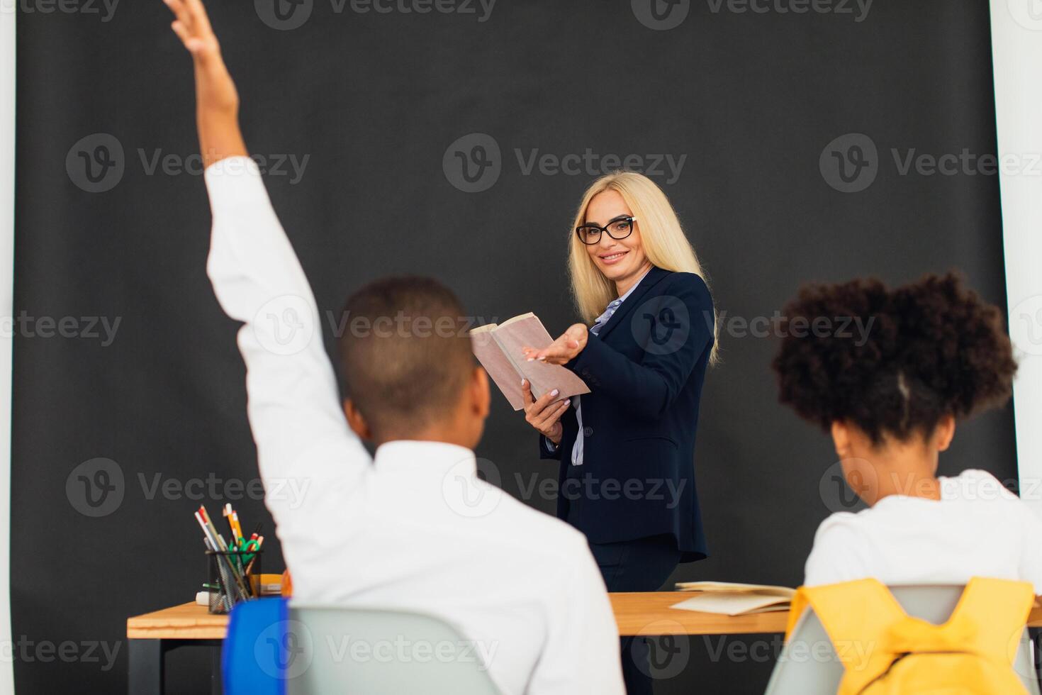 A girl and a boy, African-American school children, solve problems with the teacher during a lesson. Back to school. photo