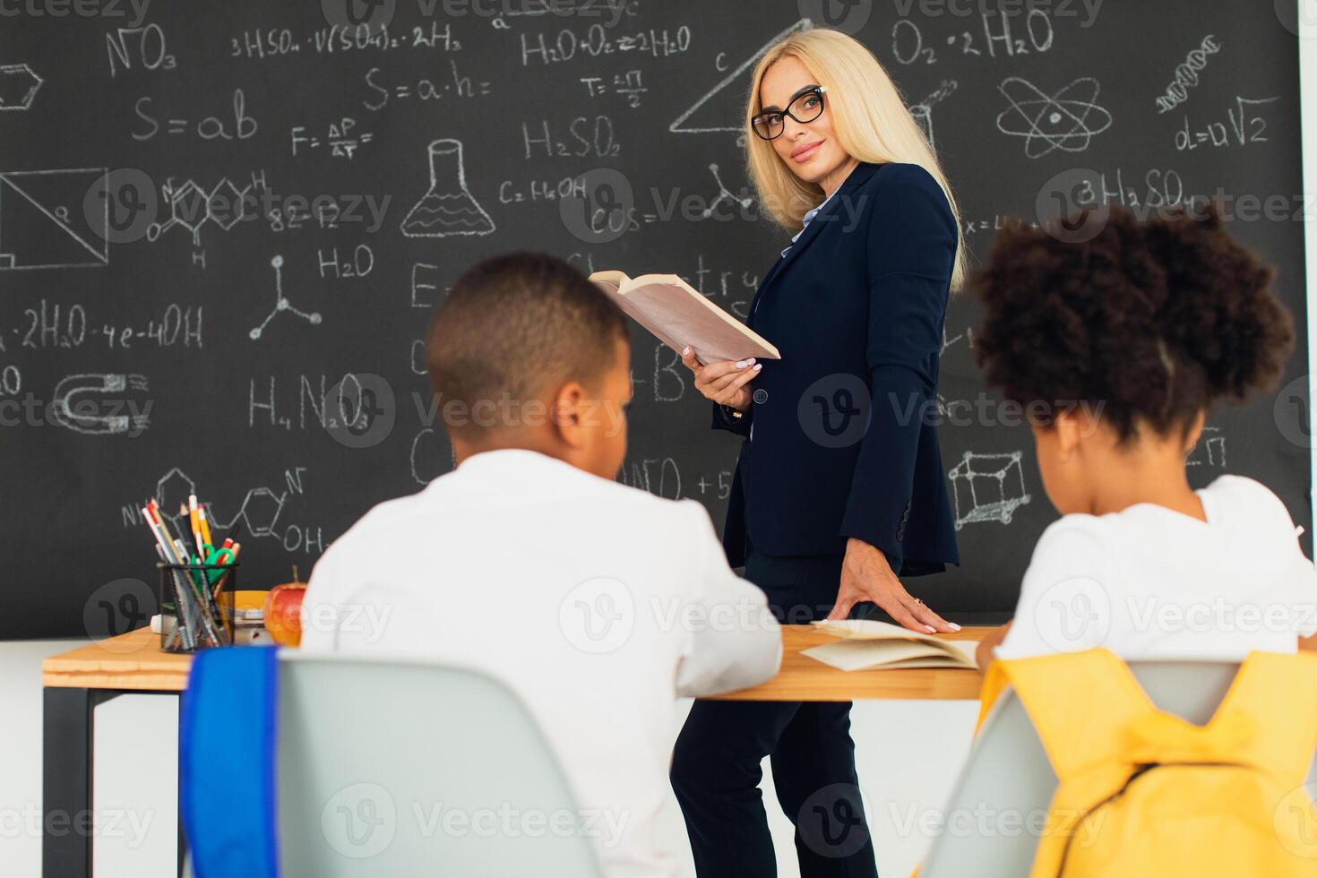 A girl and a boy, African-American school children, solve problems with the teacher during a lesson. Back to school. photo