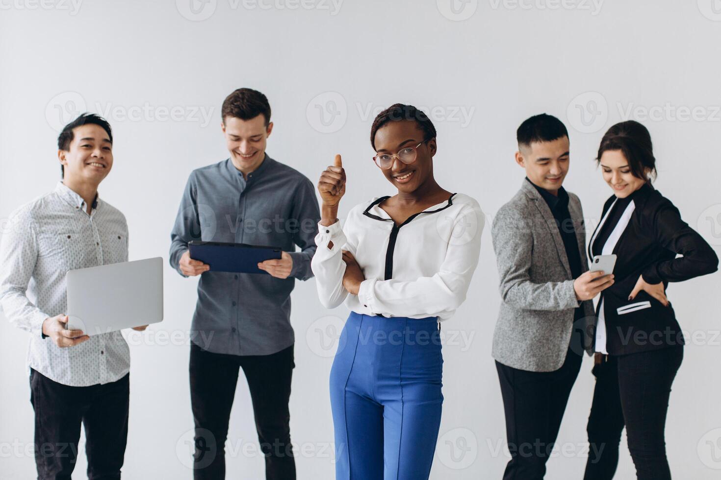 Group of multicultural young executive people standing and busy using smartphones for work in the office. Social media technology and online business with teenager lifestyle concept photo