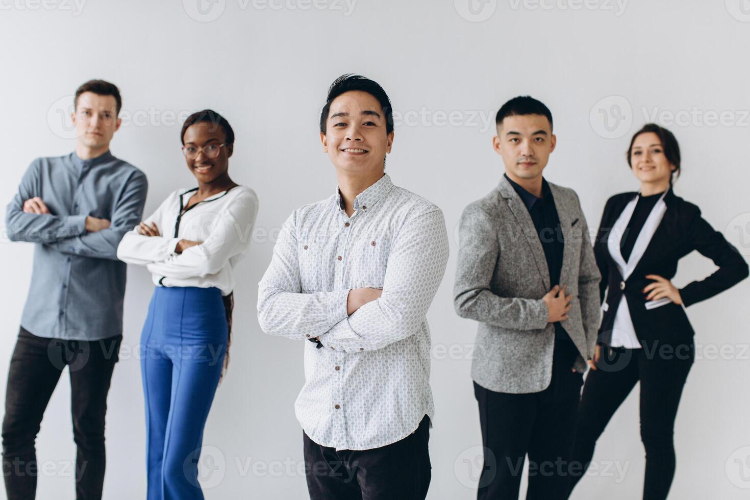 Cheerful multiracial professional business people laughing together standing in row near wall, happy diverse young employees students group, corporate staff team having fun, human resource concept photo