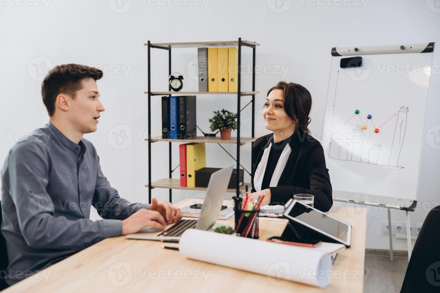Young man having an interview or business meeting with employer. Employer examining in a modern office interior photo