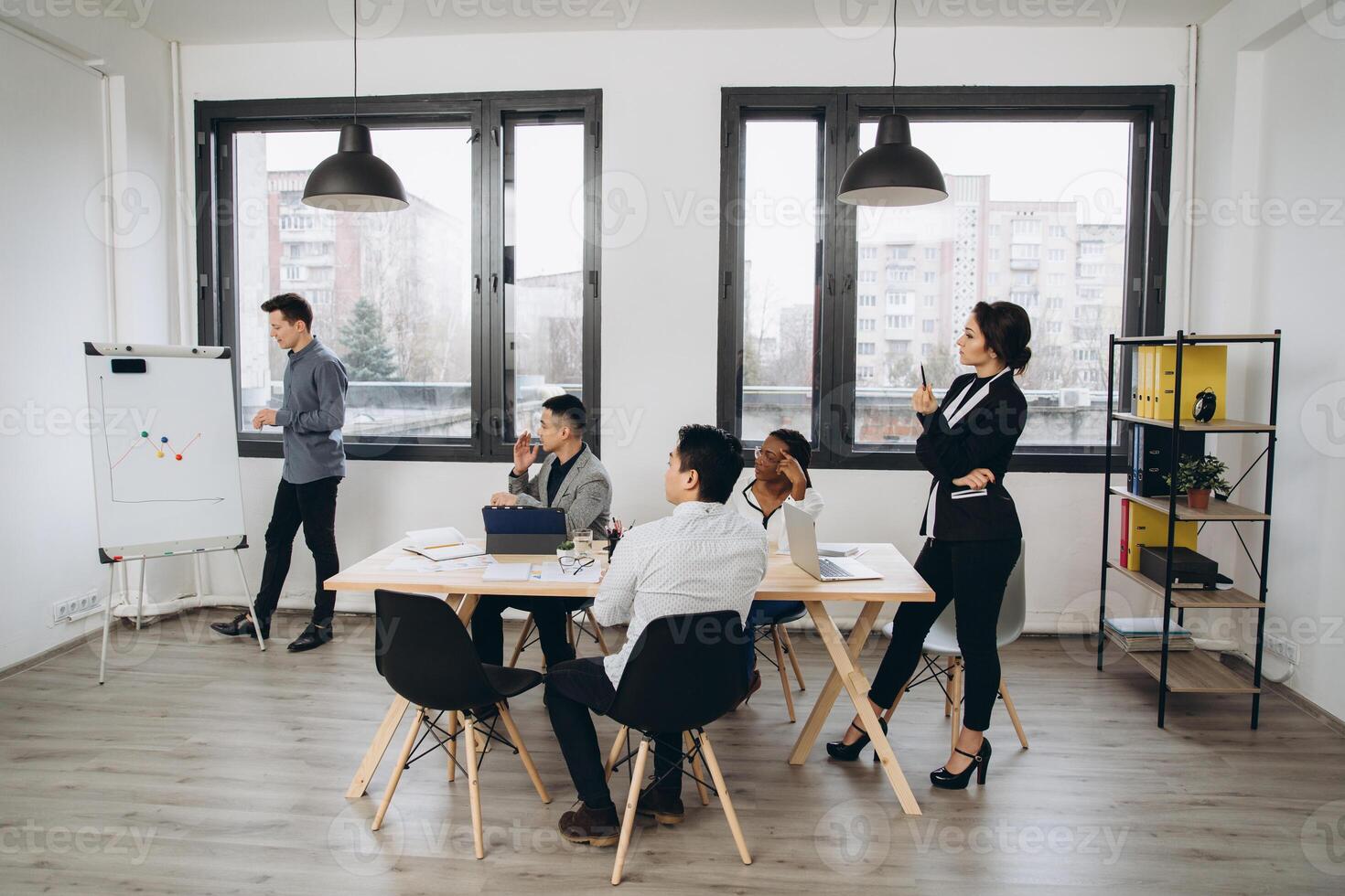 Group of positive multicultural marketing experts planning working process and sharing ideas while creating advertising campaign.Young colleagues collaborating together in loft interior office photo