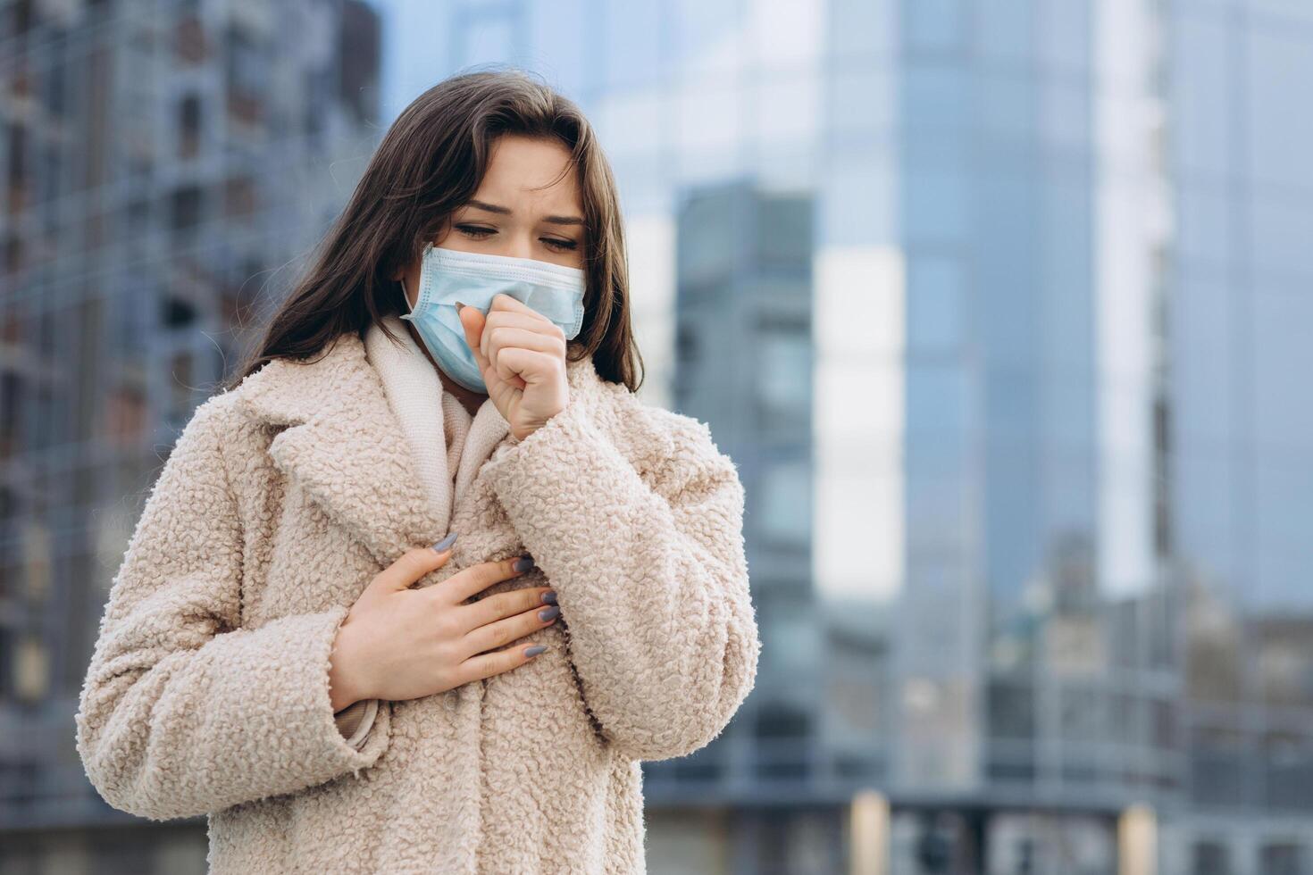 Female wearing medical protective mask outdoors. Health protection prevention during flu virus outbreak, coronavirus COVID-19 epidemic and infectious diseases in the city photo