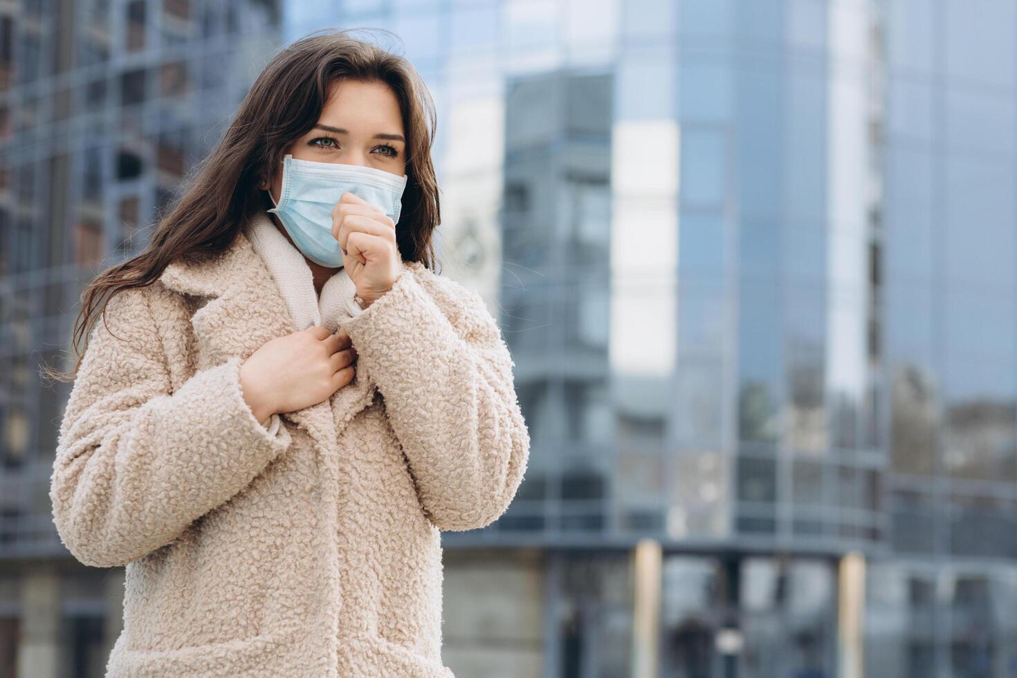 Female wearing medical protective mask outdoors. Health protection prevention during flu virus outbreak, coronavirus COVID-19 epidemic and infectious diseases in the city photo