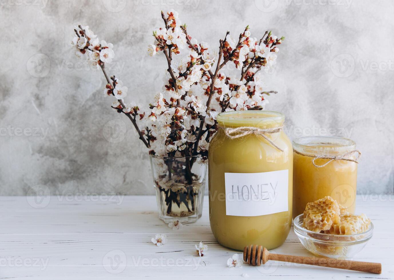 Spring composition, fresh honey with honeycomb, blooming cherry on a flat lay background photo