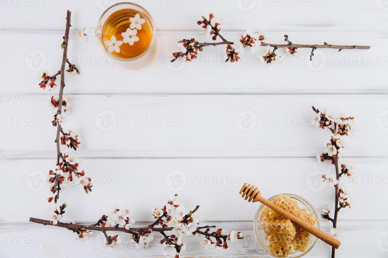 Spring composition. Frame with cup of herbal tea, a jar of honey and cherry flowers, top view. Healthy food concept photo