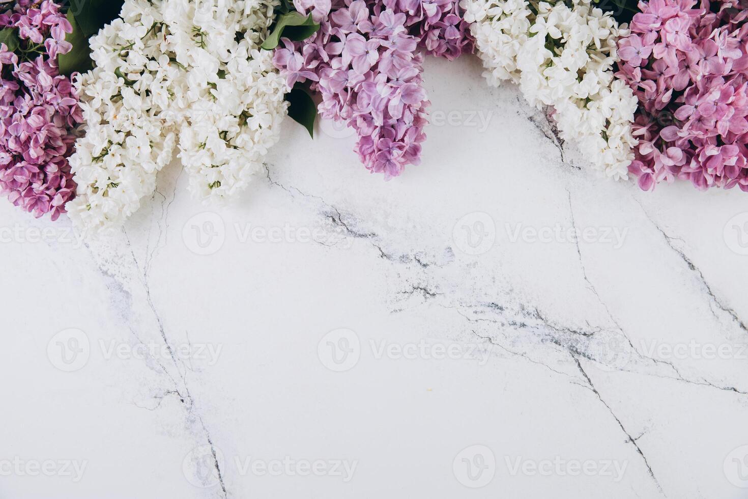 Floral pattern of a branch of lilac on a trendy marble background. Top view. Flat lay. Spring concept. Copy space photo