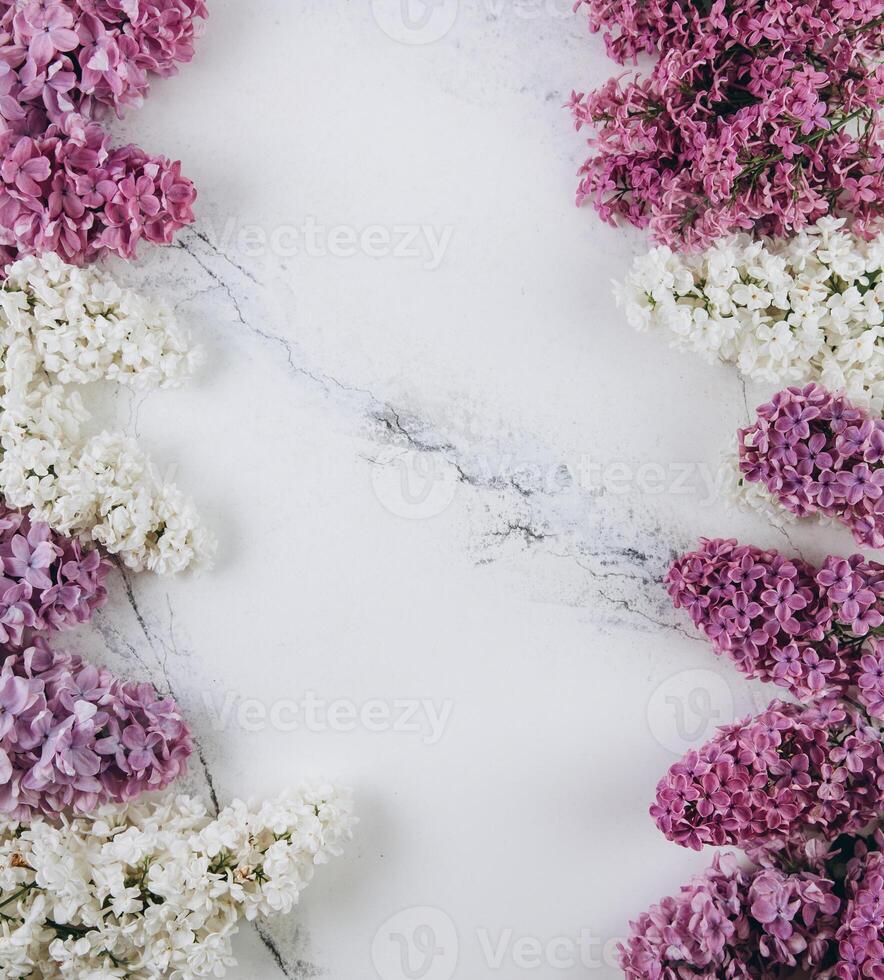 Floral pattern of a branch of lilac on a trendy marble background. Top view. Flat lay. Spring concept. Copy space photo
