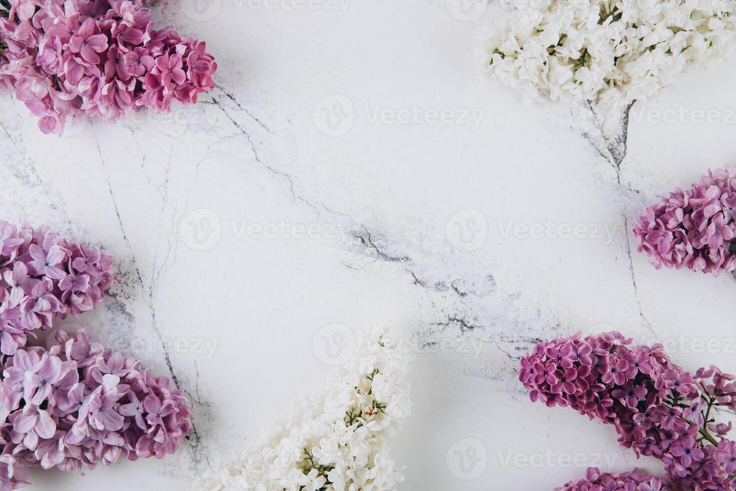 Floral pattern of a branch of lilac on a trendy marble background. Top view. Flat lay. Spring concept. Copy space photo