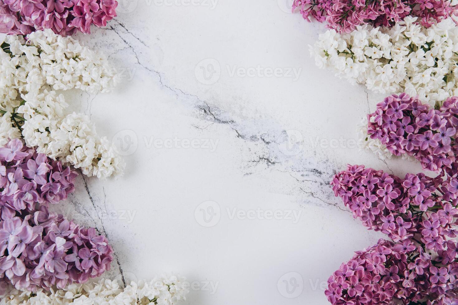 Floral pattern of a branch of lilac on a trendy marble background. Top view. Flat lay. Spring concept. Copy space photo