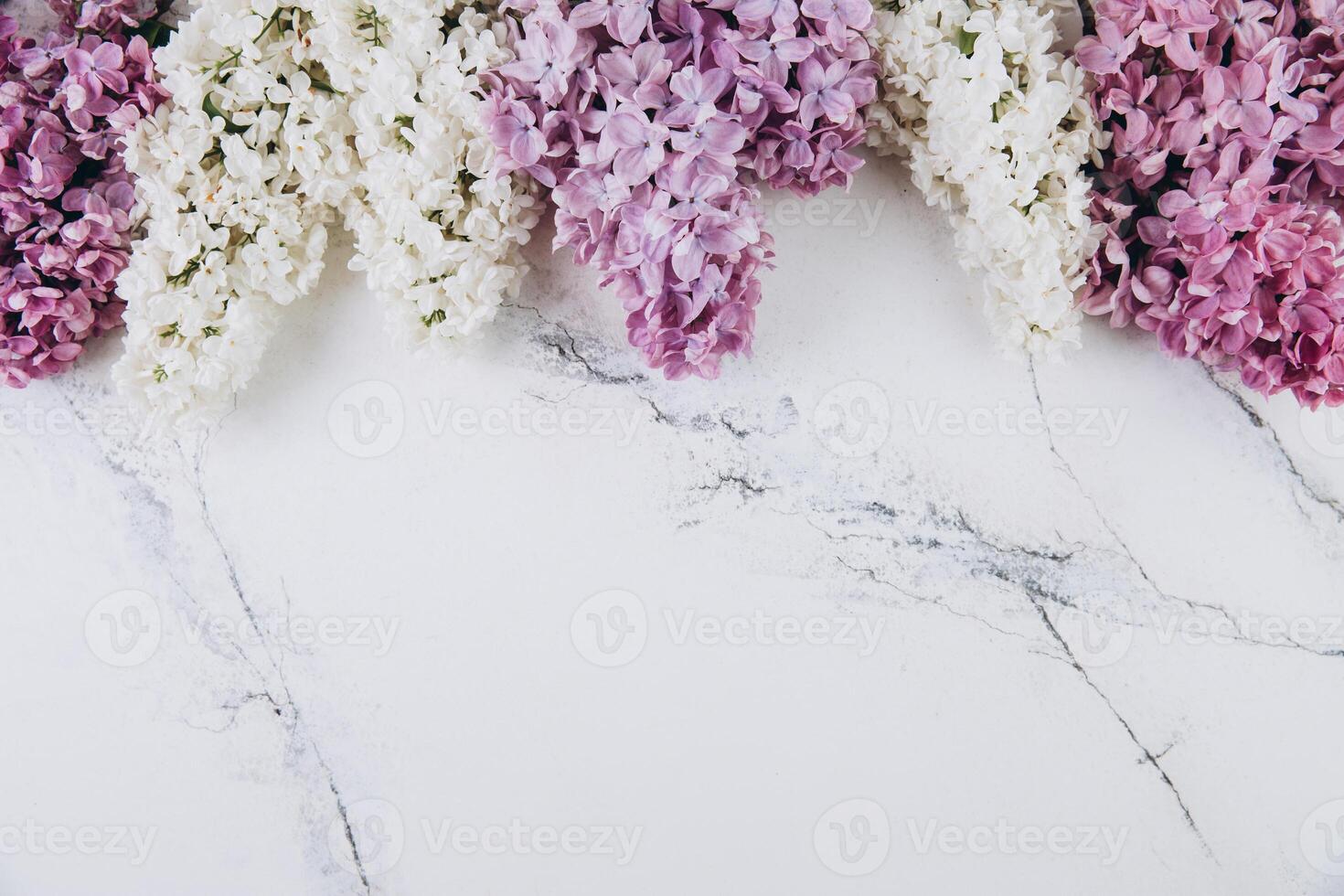 Floral pattern of a branch of lilac on a trendy marble background. Top view. Flat lay. Spring concept. Copy space photo