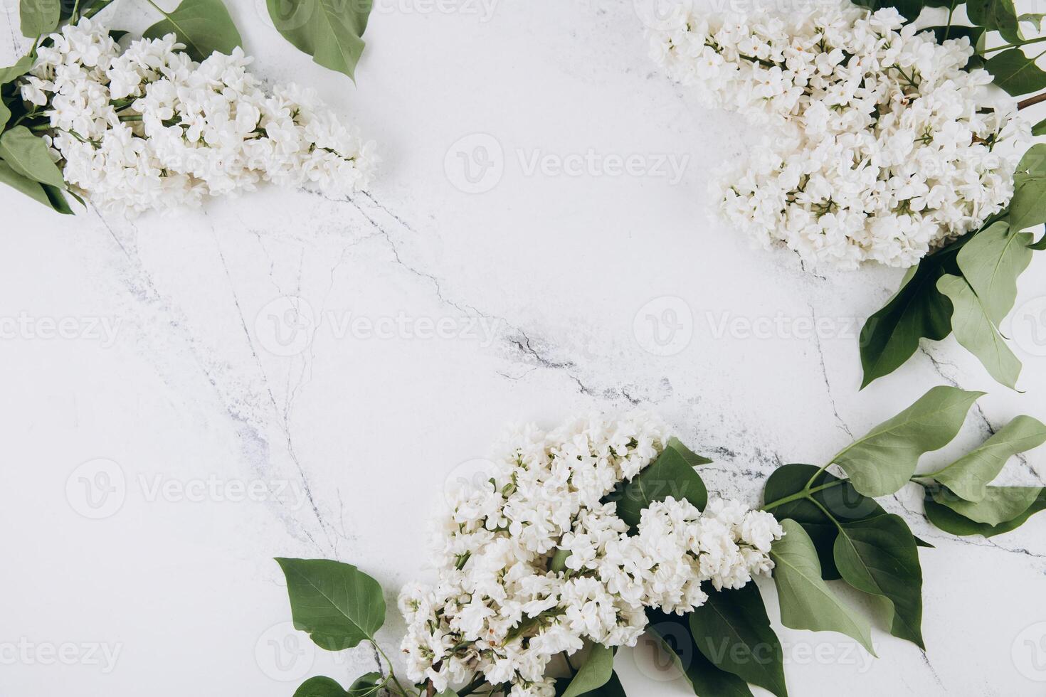 Floral pattern of a branch of lilac on a trendy marble background. Top view. Flat lay. Spring concept. Copy space photo
