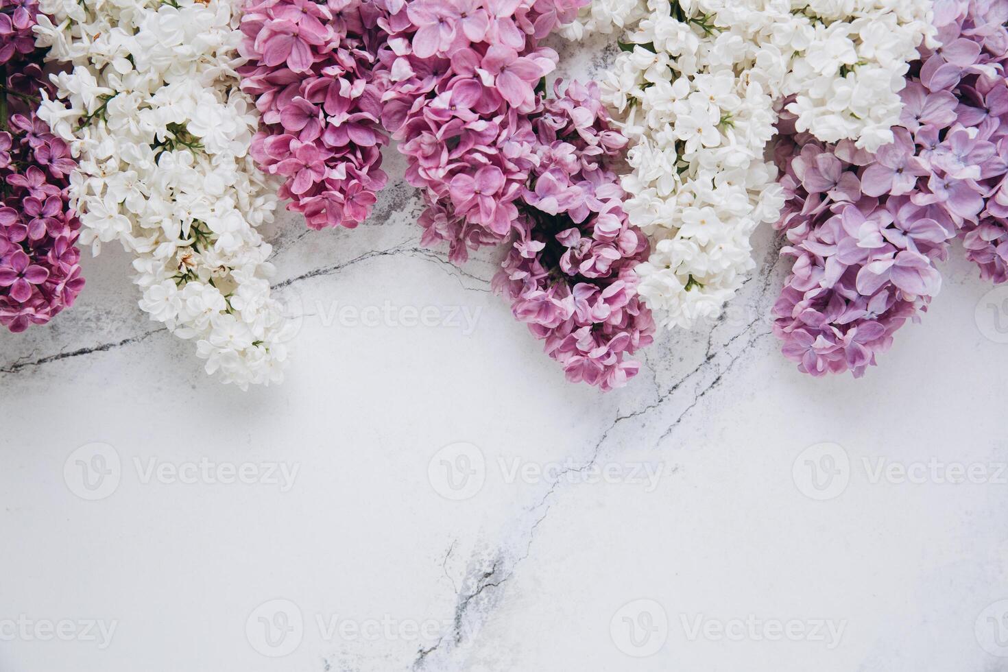 Floral pattern of a branch of lilac on a trendy marble background. Top view. Flat lay. Spring concept. Copy space photo