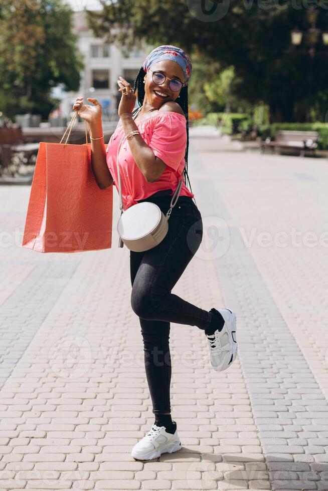 Young african american woman on the street with shopping bags photo