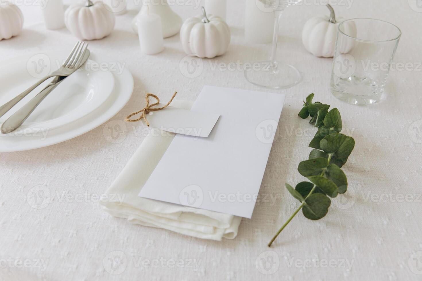 Thanksgiving table setting, tableware and decorations. Blank white postcard on table mockup. photo