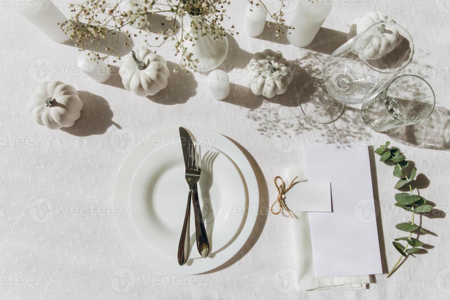 Thanksgiving table setting, tableware and decorations. Blank white postcard on table mockup, top view photo