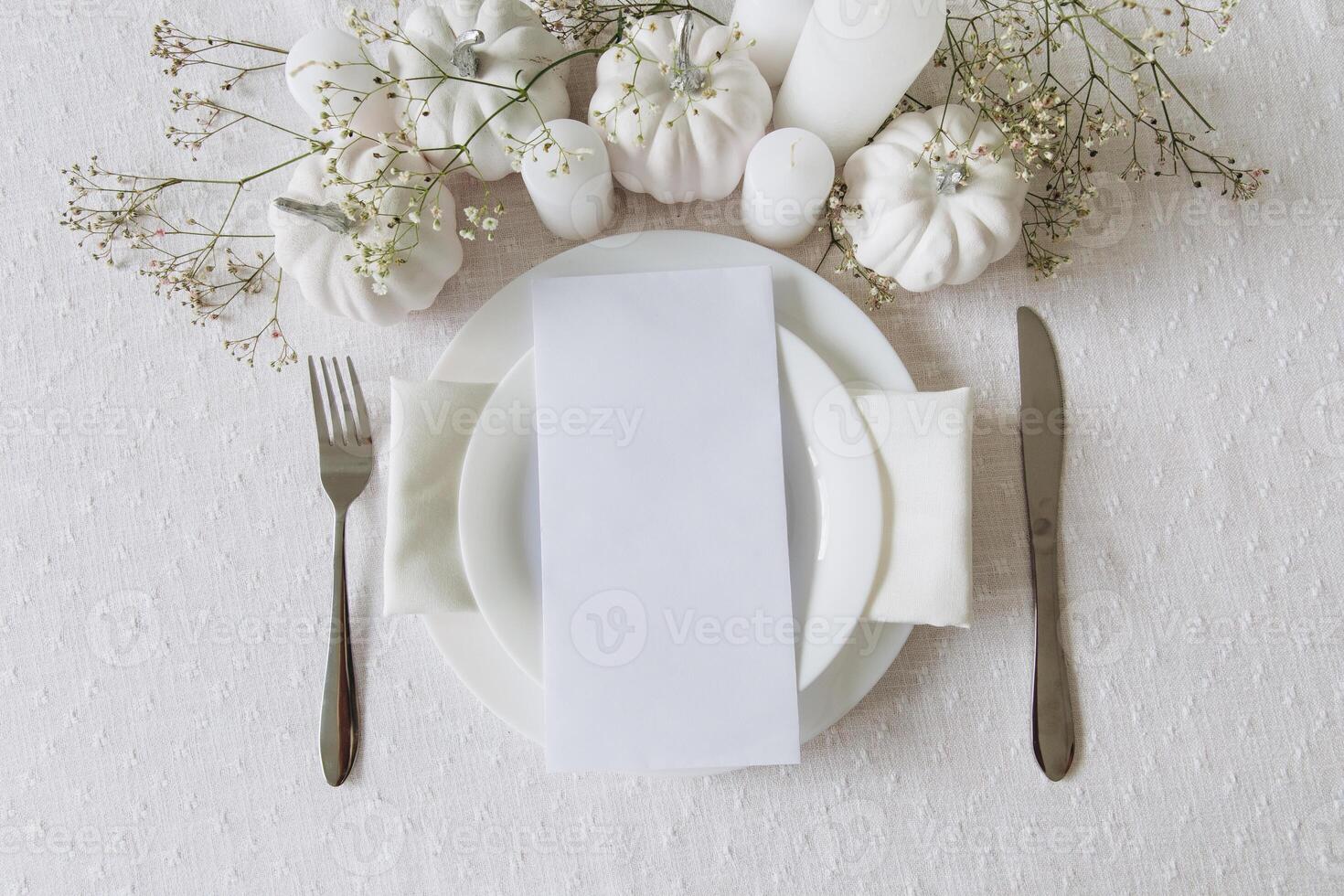 Thanksgiving table setting, tableware and decorations. Blank white postcard on table mockup, top view photo