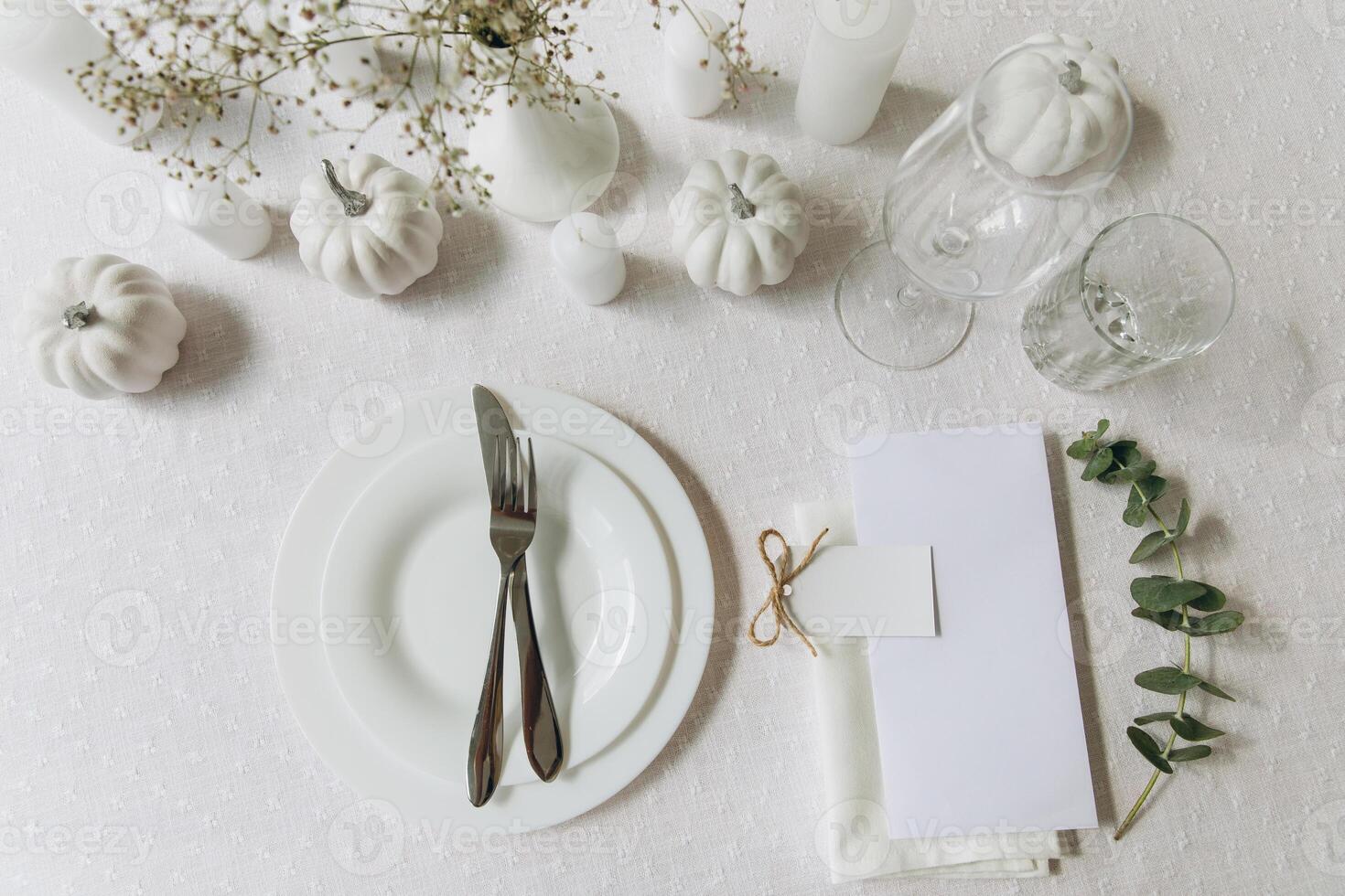 Thanksgiving table setting, tableware and decorations. Blank white postcard on table mockup, top view photo