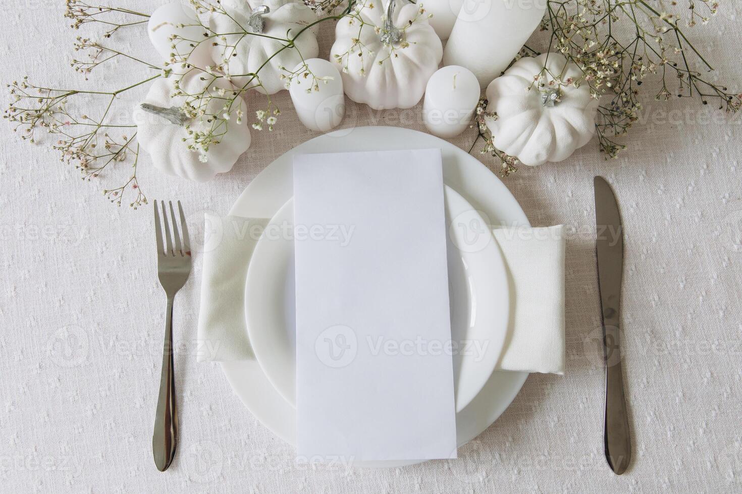 Thanksgiving table setting, tableware and decorations. Blank white postcard on table mockup, top view photo