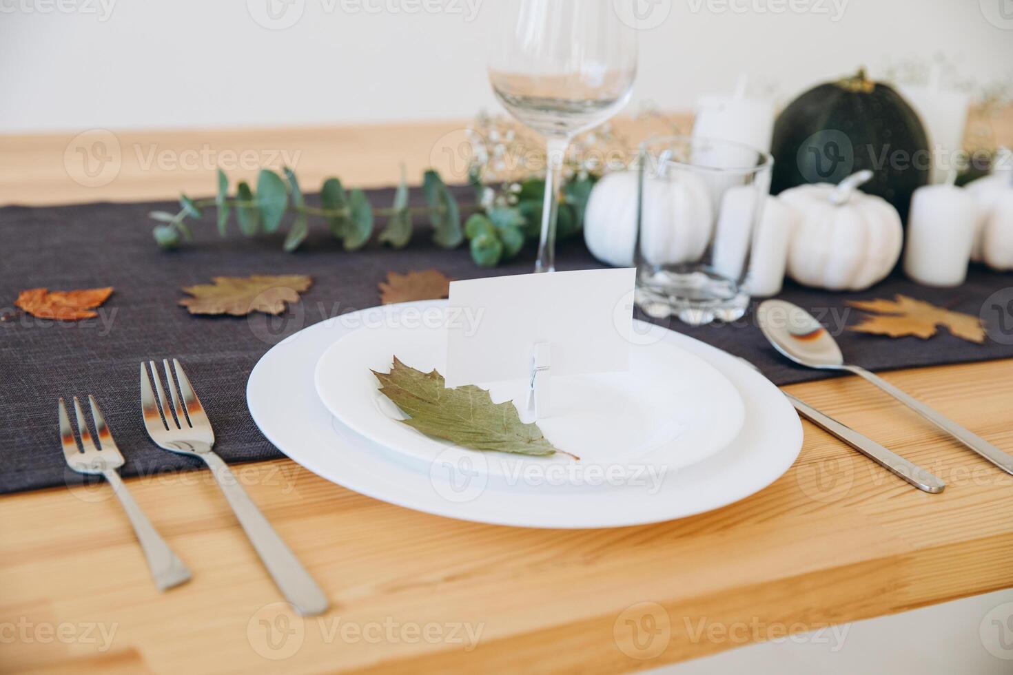 Thanksgiving table setting, tableware and decorations. Blank white postcard on table mockup. photo