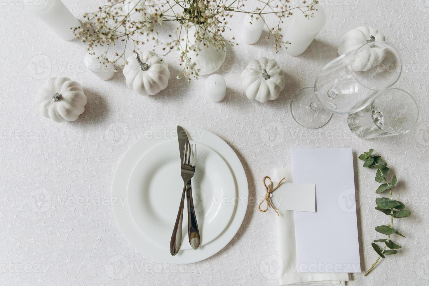 Thanksgiving table setting, tableware and decorations. Blank white postcard on table mockup, top view photo
