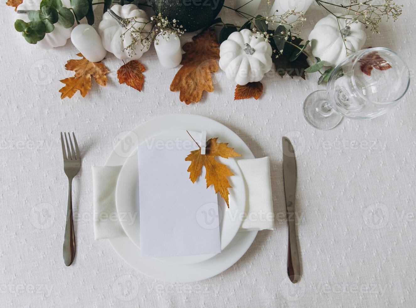 Thanksgiving table setting, tableware and decorations. Blank white postcard on table mockup, top view photo