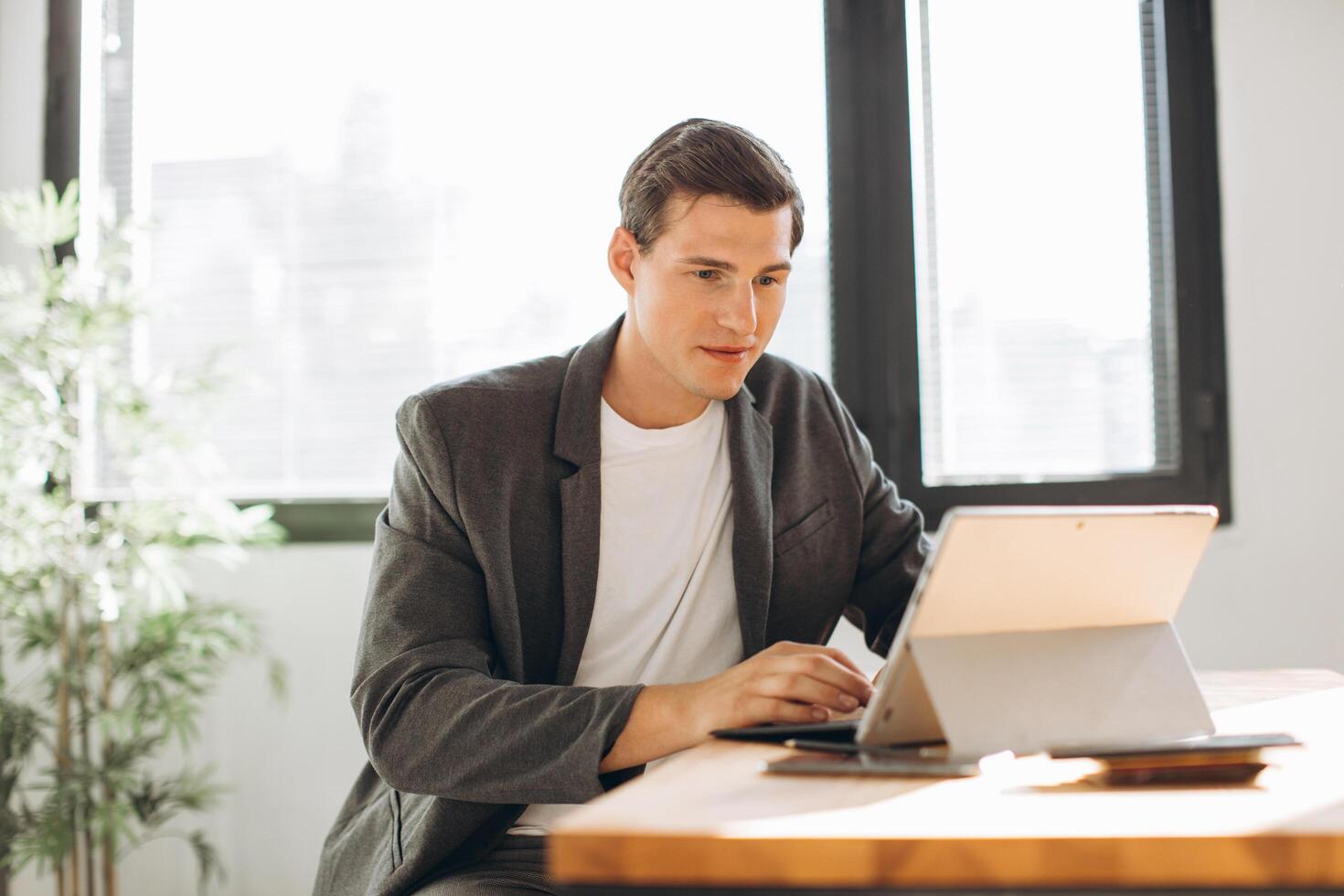 Modern smiling man, office worker working in the office at the computer photo