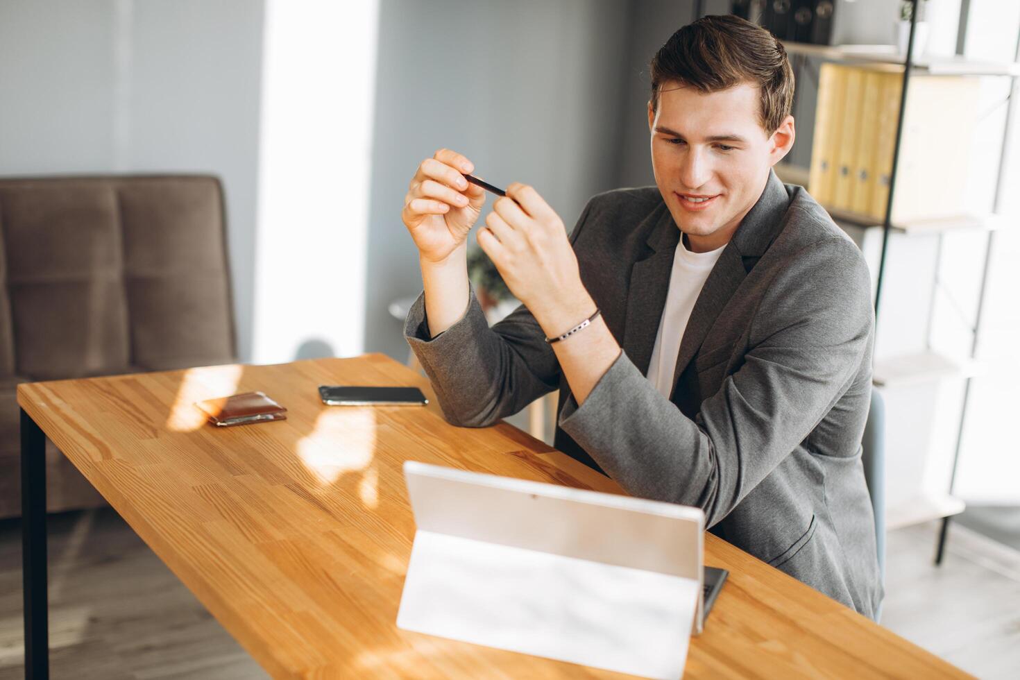 Modern smiling man, office worker working in the office at the computer photo