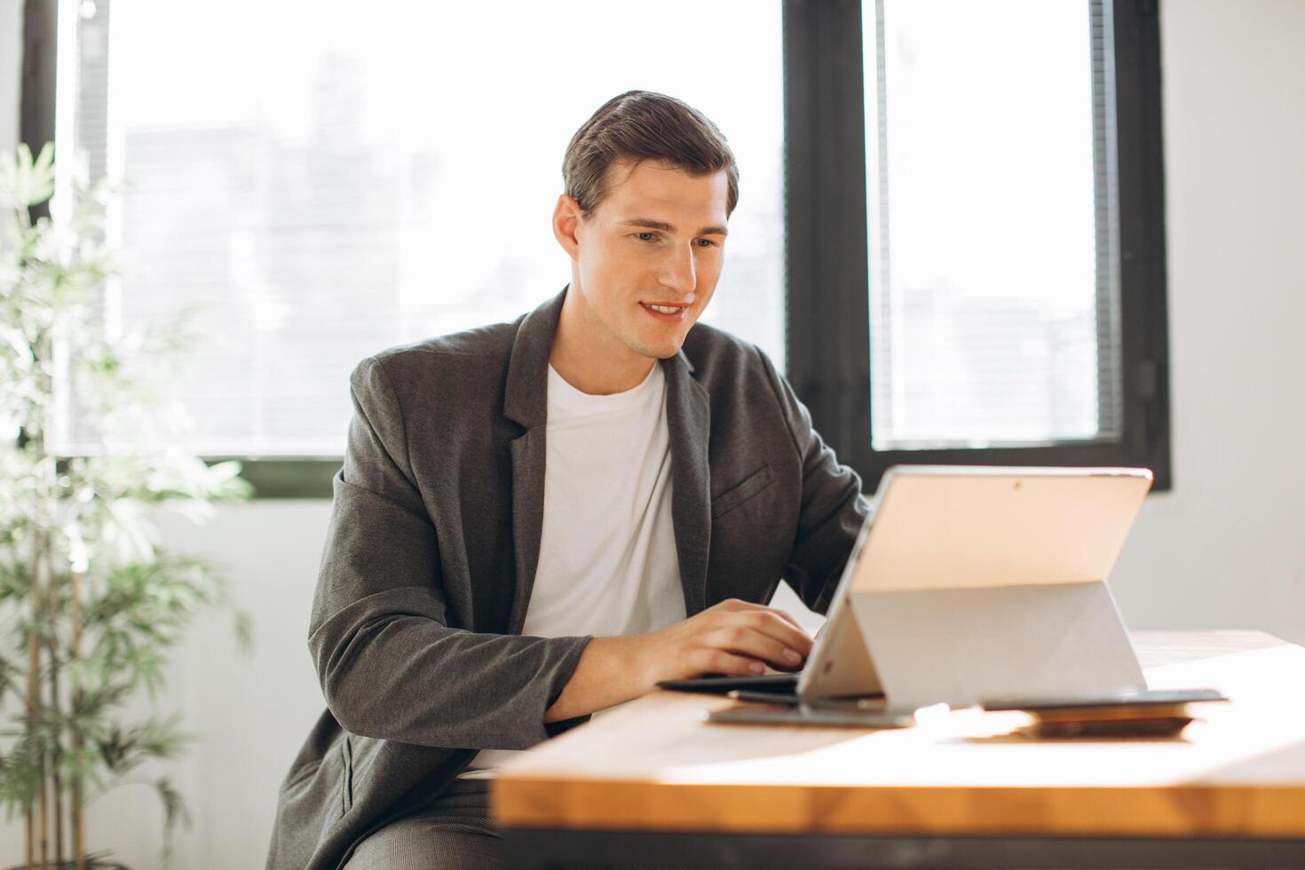 Modern smiling man, office worker working in the office at the computer photo