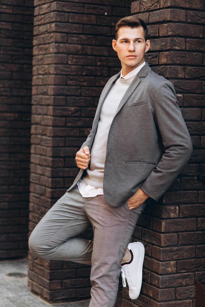 Modern handsome smiling man walking down the street and posing photo