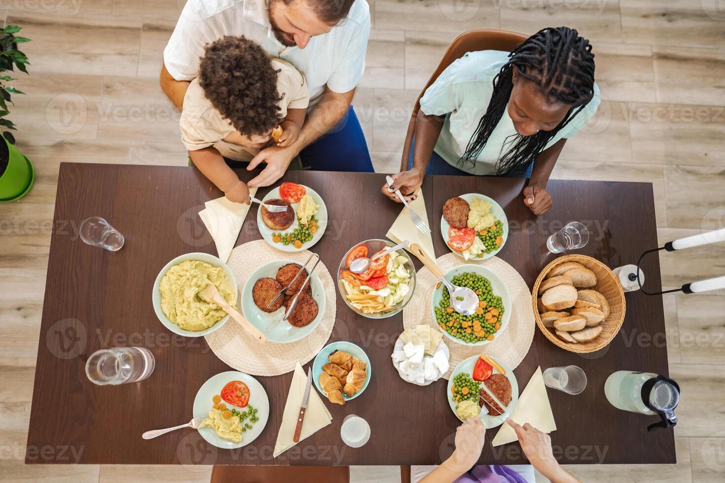 Family enjoying a hearty meal together in a cozy dining room photo