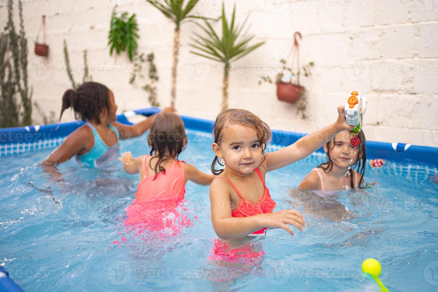 Children enjoying a fun day in a backyard pool under bright sunlight photo