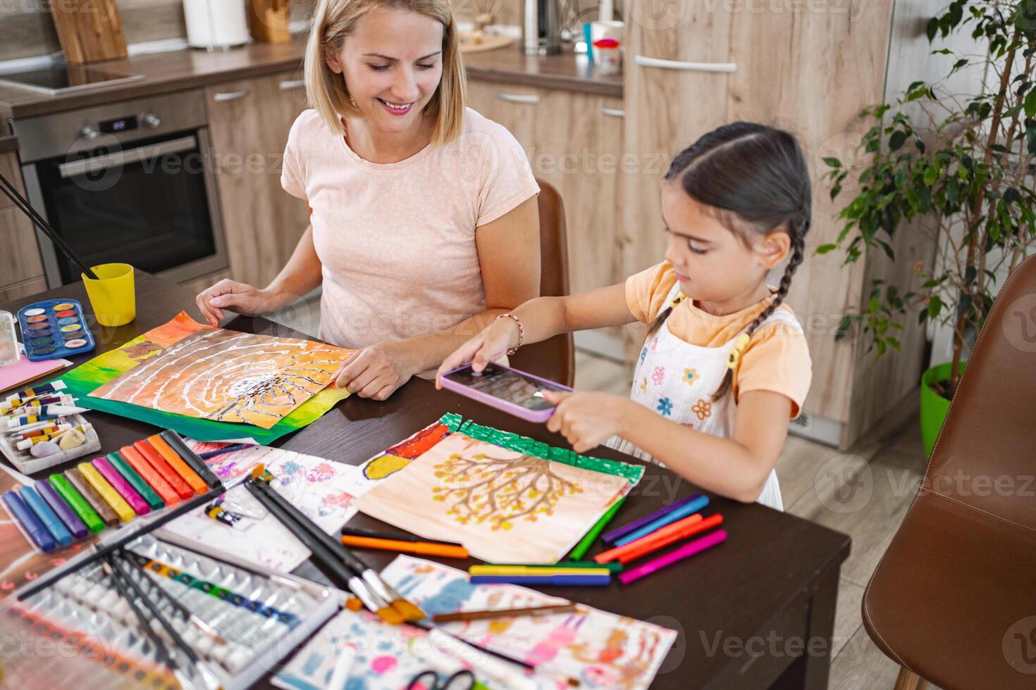 Mother and daughter take pictures of artwork with mobile camera photo