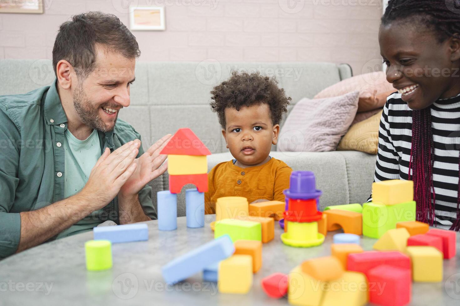 Multiracial family enjoys building with colorful blocks at home photo