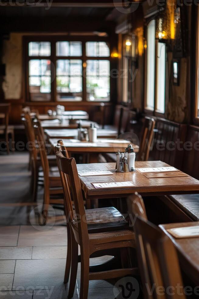 Cozy empty restaurant interior with wooden tables and chairs at dusk photo
